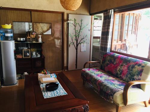 uma sala de estar com um sofá e uma mesa em Ise Chitose em Ise