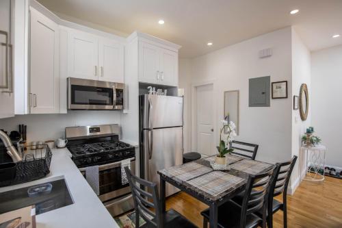 a kitchen with a table and a stainless steel refrigerator at Top Floor with Skylight Brooklyn in Brooklyn