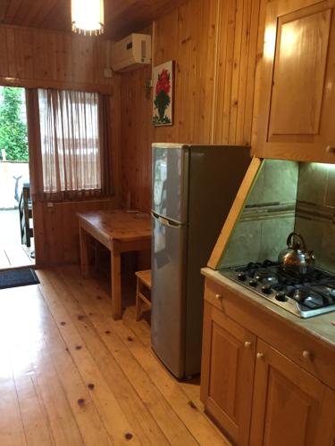 eine Küche mit einem Kühlschrank, einem Herd und einem Tisch in der Unterkunft Holiday Home in Ureki