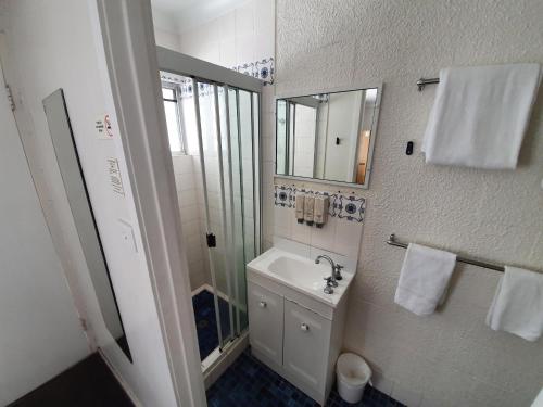 
a bathroom with a sink, toilet and shower at Metro Motel Rockhampton in Rockhampton
