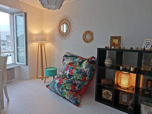un salon avec une chaise et un miroir dans l'établissement La Blanche La Rochelle Vue sur les Tours, à La Rochelle