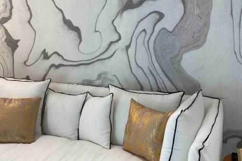 a bed with pillows and a painting on the wall at L’adoré Sainte Catherine in Bordeaux