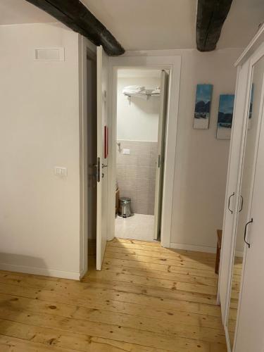 an empty room with a bathroom and a hallway with a wooden floor at Monaciello in Naples