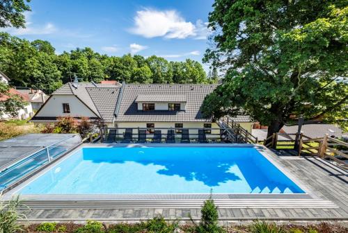una imagen de una piscina frente a una casa en Relax pension Schonwald, en Budišov nad Budišovkou