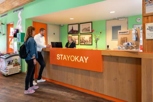 a group of people standing at a shop counter at Stayokay Hostel Egmond in Egmond-Binnen