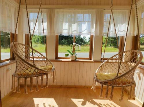 two chairs sitting in a room with windows at Hellamaa Retrovisiit Alma & Vilma in Hellamaa