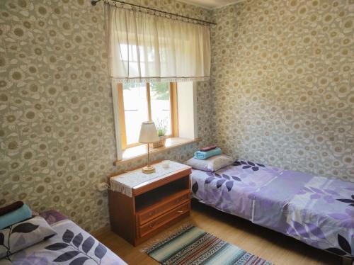 a bedroom with two twin beds and a window at Hellamaa Retrovisiit Alma & Vilma in Hellamaa