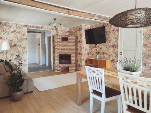 a living room with a table and a fireplace at Hellamaa Retrovisiit Alma & Vilma in Hellamaa
