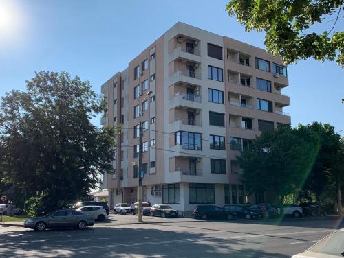 un edificio de apartamentos alto con coches estacionados en un estacionamiento en The View Apartment en Constanza