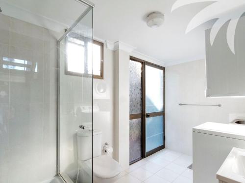 a white bathroom with a shower and a toilet at Sandbar View in Smiths Lake