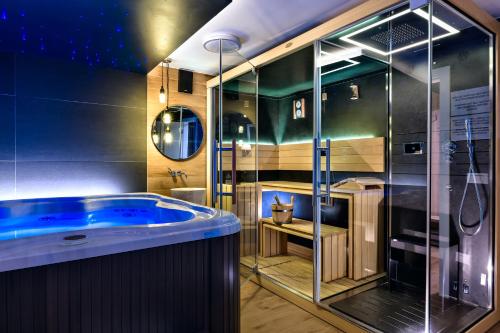 a bathroom with a blue tub and a shower at Madison Luxury Apartments & Rooms in Zagreb