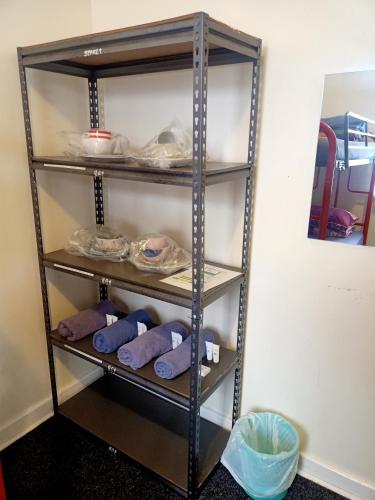 a shelf in a room with purple towels and plates at Wander Inn Bunbury in Bunbury