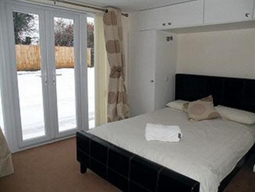 a bedroom with a bed and a large window at Mather House Retreat in Wantage