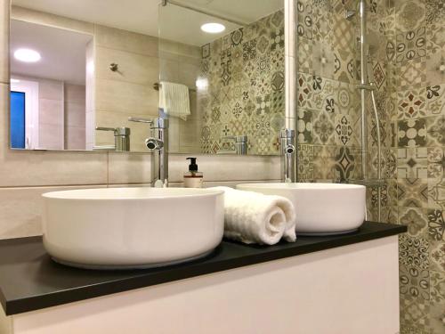 a bathroom with two white sinks on a counter at MonResidence Cavall Bernat in Manresa