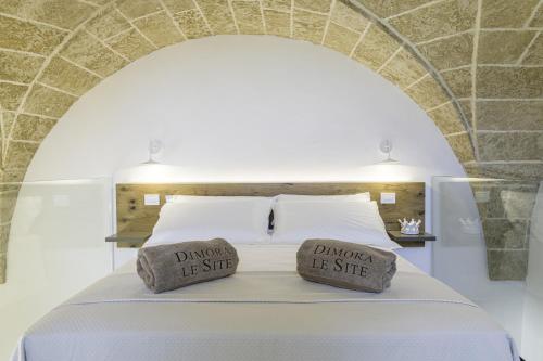 a bedroom with a bed with two pillows on it at Dimora Le Site in Torre Suda
