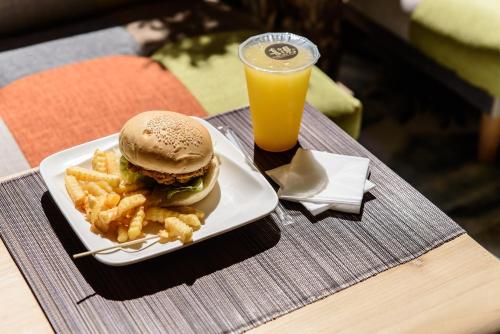 a sandwich and french fries and a drink on a table at Tree House in Anping