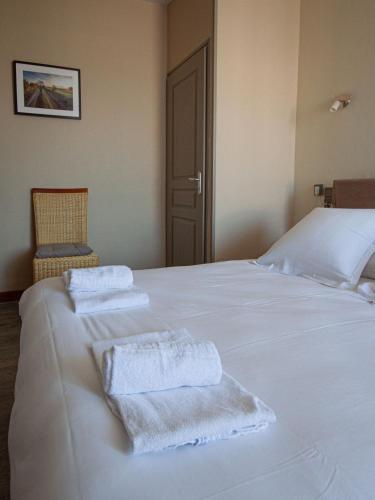 a white bed with towels sitting on top of it at lhotel in Thouars