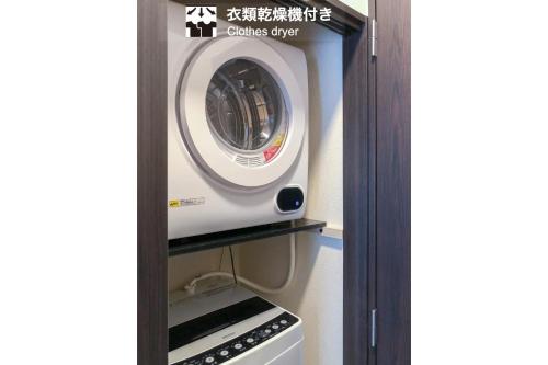 a washer and dryer on a shelf in a kitchen at Home Sweet Office Kamata in Tokyo
