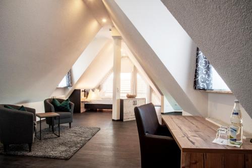 a living room with a table and chairs and a bed at Hotel & Restaurant Post in Laichingen