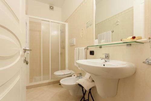 a white bathroom with a sink and a toilet at Hotel GARDENIA & Villa CHARME Adults Friendly 10Plus in Bardolino
