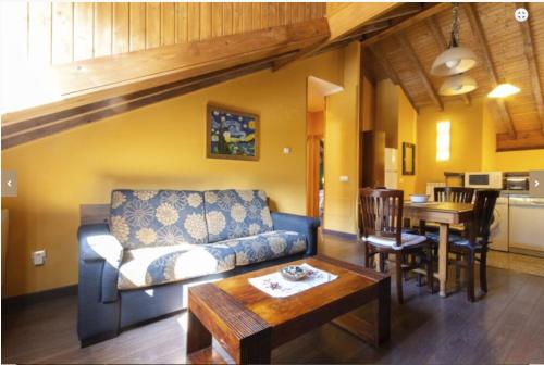 a living room with a couch and a table at Apartamentos Rurales Les Martes in Felechosa
