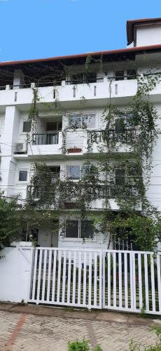 a white building with a white fence in front of it at La Lune Fort Kochi in Cochin