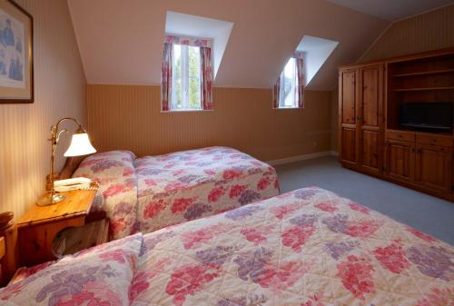 a bedroom with two beds and a dresser and a table at Forest Villa Huis Ten Bosch in Sasebo