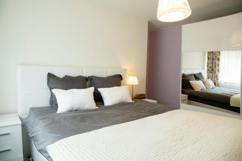 a bedroom with a large bed with a large mirror at Beautiful family house 5 min away from Amsterdam in Badhoevedorp