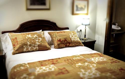 - un lit avec des oreillers dans une chambre dans l'établissement Apartamentos en pleno centro, Aljibe Rodrigo del Campo 1A, à Grenade