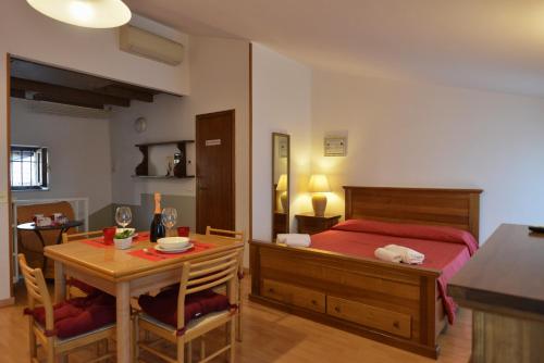 a bedroom with a bed and a table and chairs at Taverna Affittacamere in Gardone Riviera
