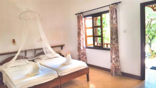 two beds in a room with a hanging bed at Bernique Guesthouse in La Digue