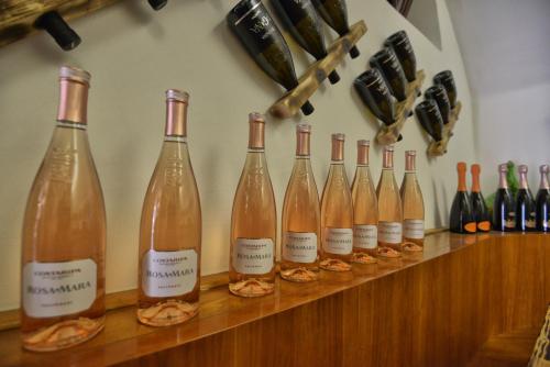 a row of wine bottles sitting on a counter at Taverna Affittacamere in Gardone Riviera