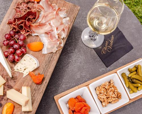 una mesa con queso y carne y una copa de vino en Chesa Valese, en Zermatt