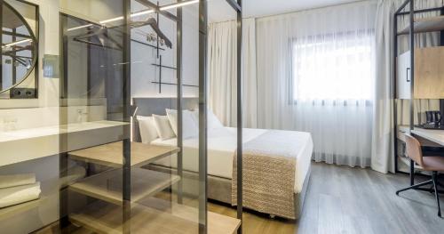 a hotel room with a bed and a desk and a desk at Hotel Ilunion San Mamés in Bilbao
