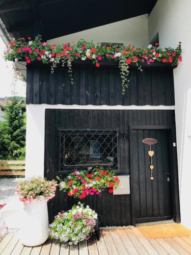 a house with a black door with flowers on it at Landhaus Zirben in Bad Kleinkirchheim