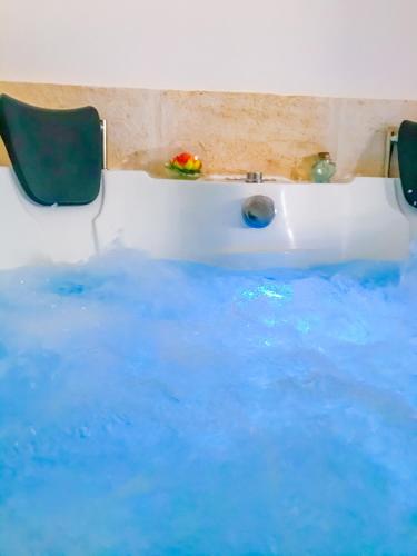 a bath tub filled with blue water with a sink at La Mignola in Fasano
