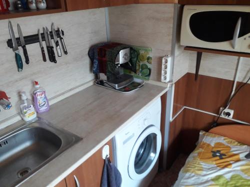 a kitchen with a sink and a washing machine at Удобство in Burgas City