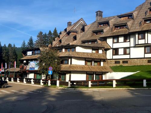 a large building with a wooden roof at Apartments JAT Kopaonik in Kopaonik