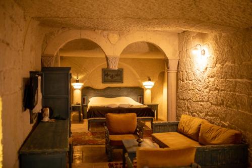 a bedroom with a bed and a couch in a room at Pome Granate Cave Hotel in Nevşehir