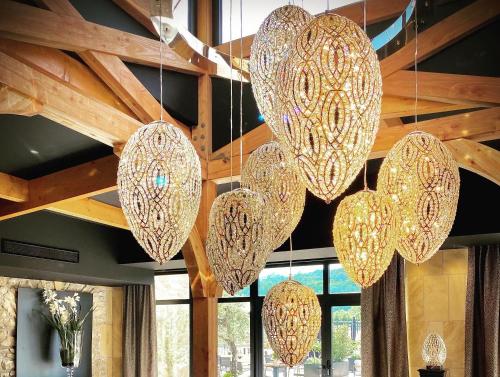 a group of chandeliers hanging from a ceiling at Domaine de la Klauss & Spa, Restaurant Gastronomique Le K in Montenach