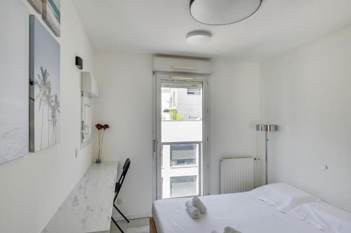 a white room with a bed and a window at DIFY Splendide - Jean Mace in Lyon