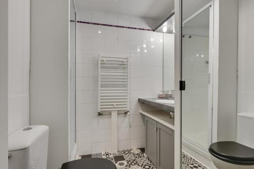 une salle de bain blanche avec des toilettes et un lavabo dans l'établissement DIFY Splendide - Jean Mace, à Lyon