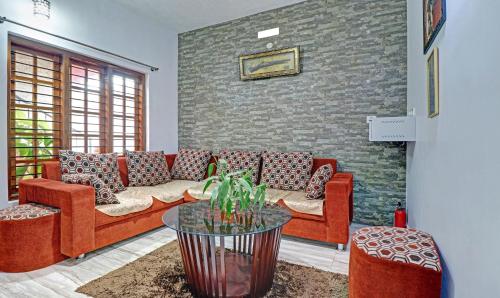 a living room with red couches and a brick wall at Treebo Avyukta Stay in Madikeri