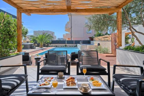 una mesa con comida en un patio con piscina en Liberty Living Apartments, en Split