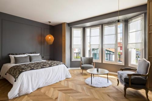 une chambre avec un lit, deux chaises et une table dans l'établissement Libertitu, à Bayonne