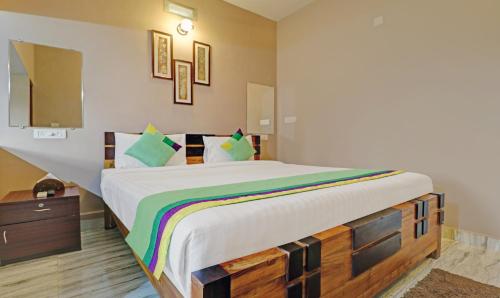 a bedroom with a large bed with a wooden frame at Treebo Avyukta Stay in Madikeri