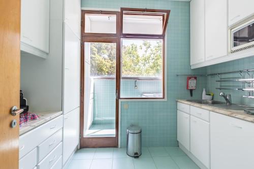 una cocina con fregadero y una ventana. en Pasteleira Relaxing Apartment, en Oporto
