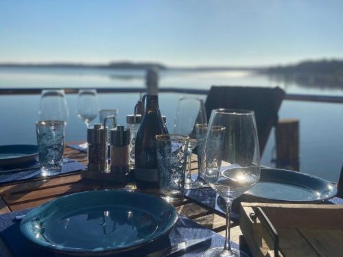 una mesa con copas de vino y botellas de vino. en Hausboot La Mesa, en Lychen