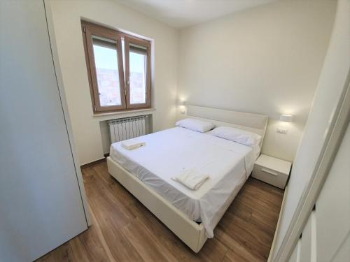 a bedroom with a white bed and a window at Appartamenti Borgo Panoramico N 9 in Tropea
