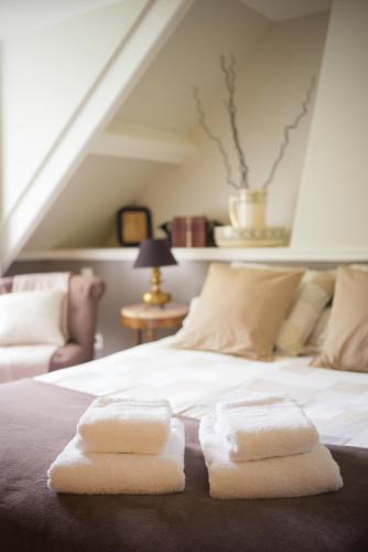 a bedroom with a bed with two towels on it at Manoir du Clap in La Cerlangue